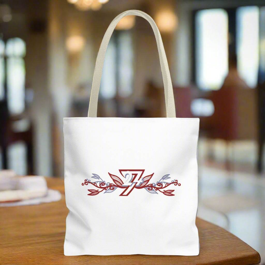 Small tote bag with floral design and beige handle placed on a wooden table