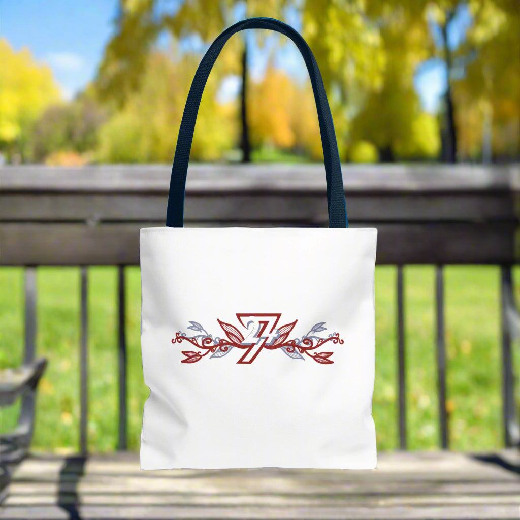 Unique floral design on white tote bag with black handle placed on a bech in a park
