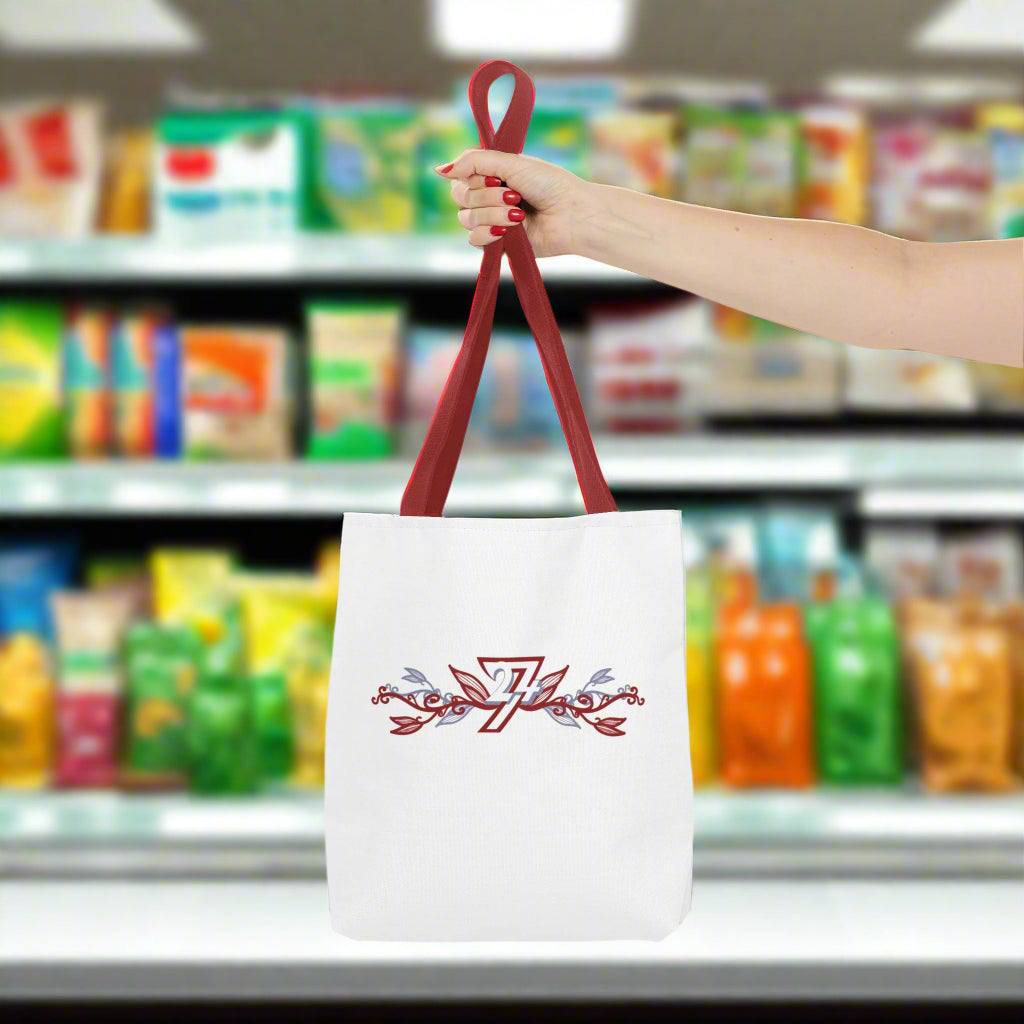 White small tote bag with red handle shown by a woman in a grocery shop