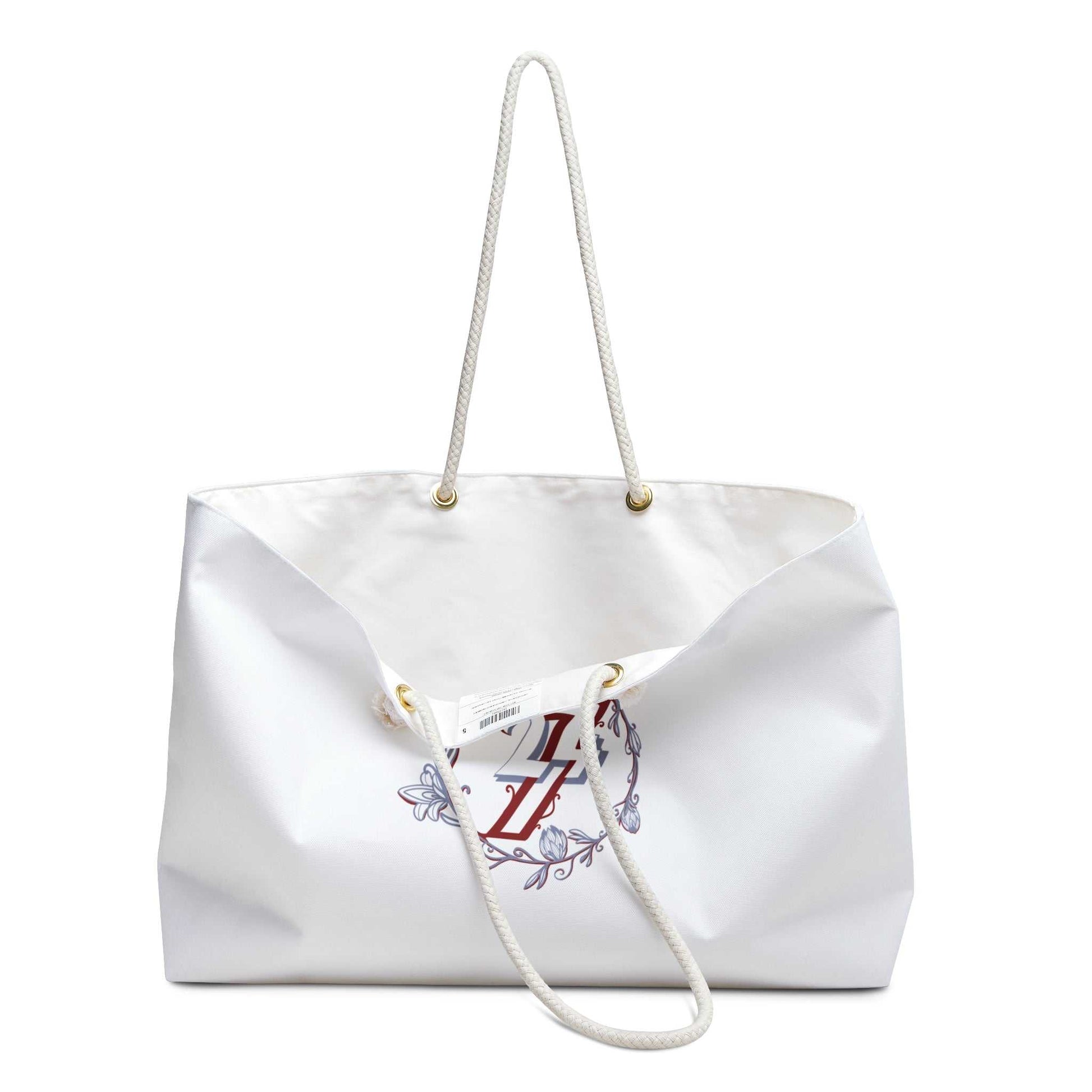 Slightly open view of the aesthetic overnight bag, showing the crisp white exterior, gold grommets, and the thick 27-inch rope handles.