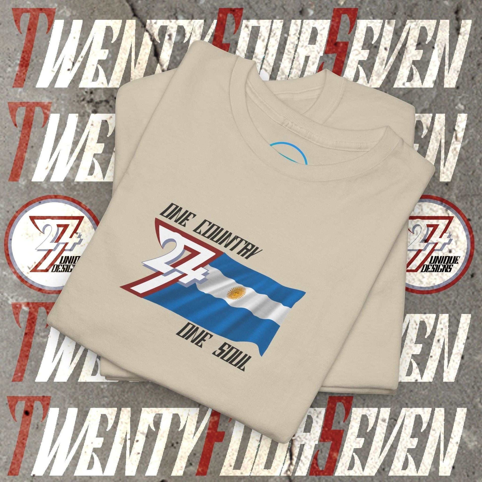 A professional display of the Argentina flag t-shirt in Beige, folded to showcase the refined hand-drawn graphic and high-quality fabric finish.