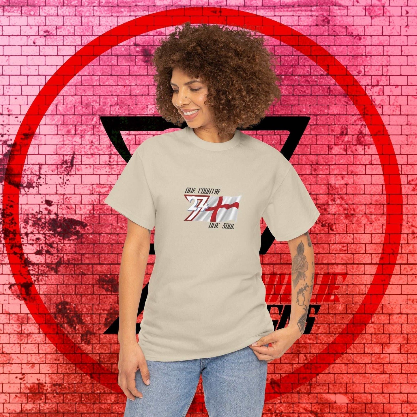 Female model wearing the England "Valor" edition tee in Light Heather Gray, showing a clean, refined streetwear look.