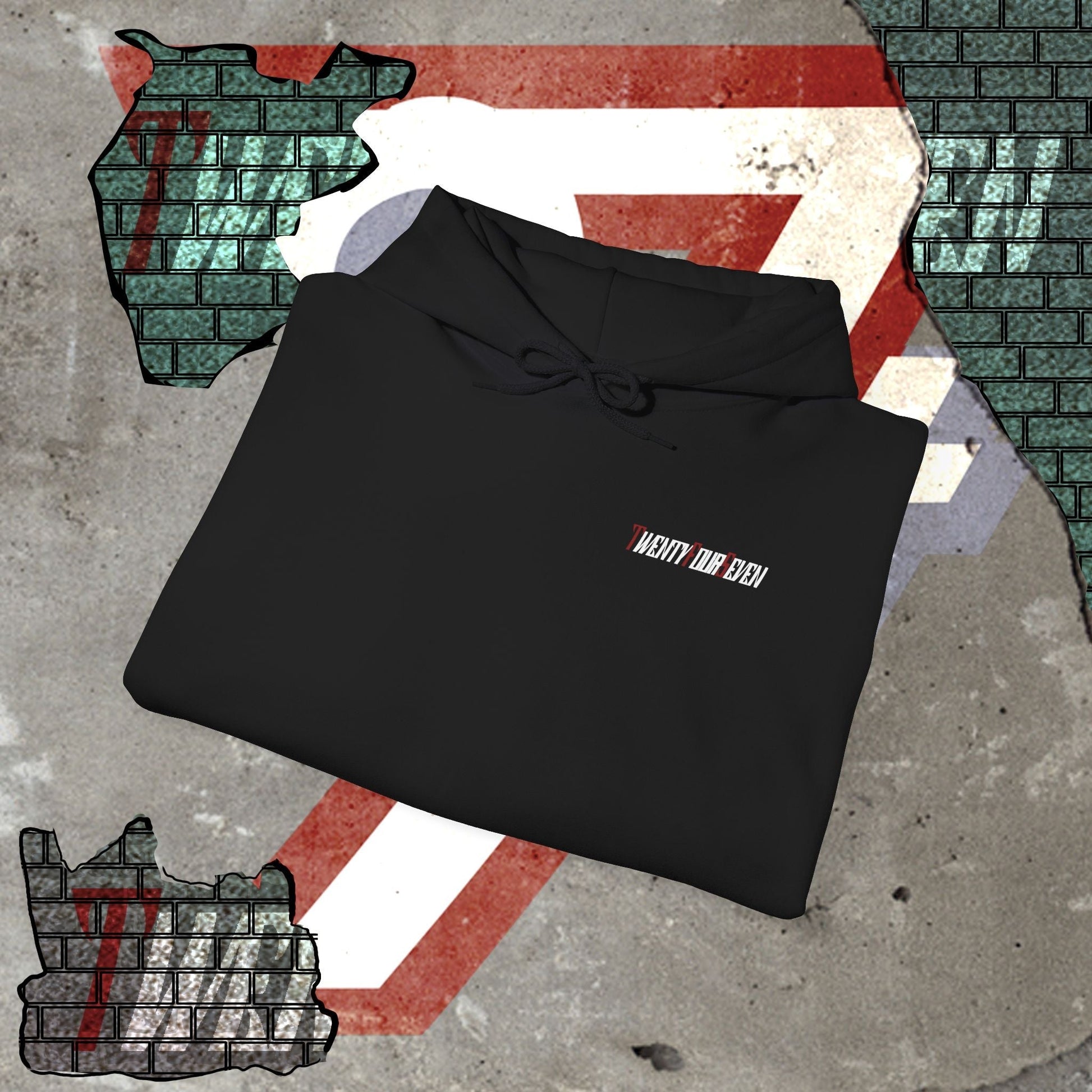 black printed hoodie with twentyfourseven logo folded on concrete surface with painted graphic background