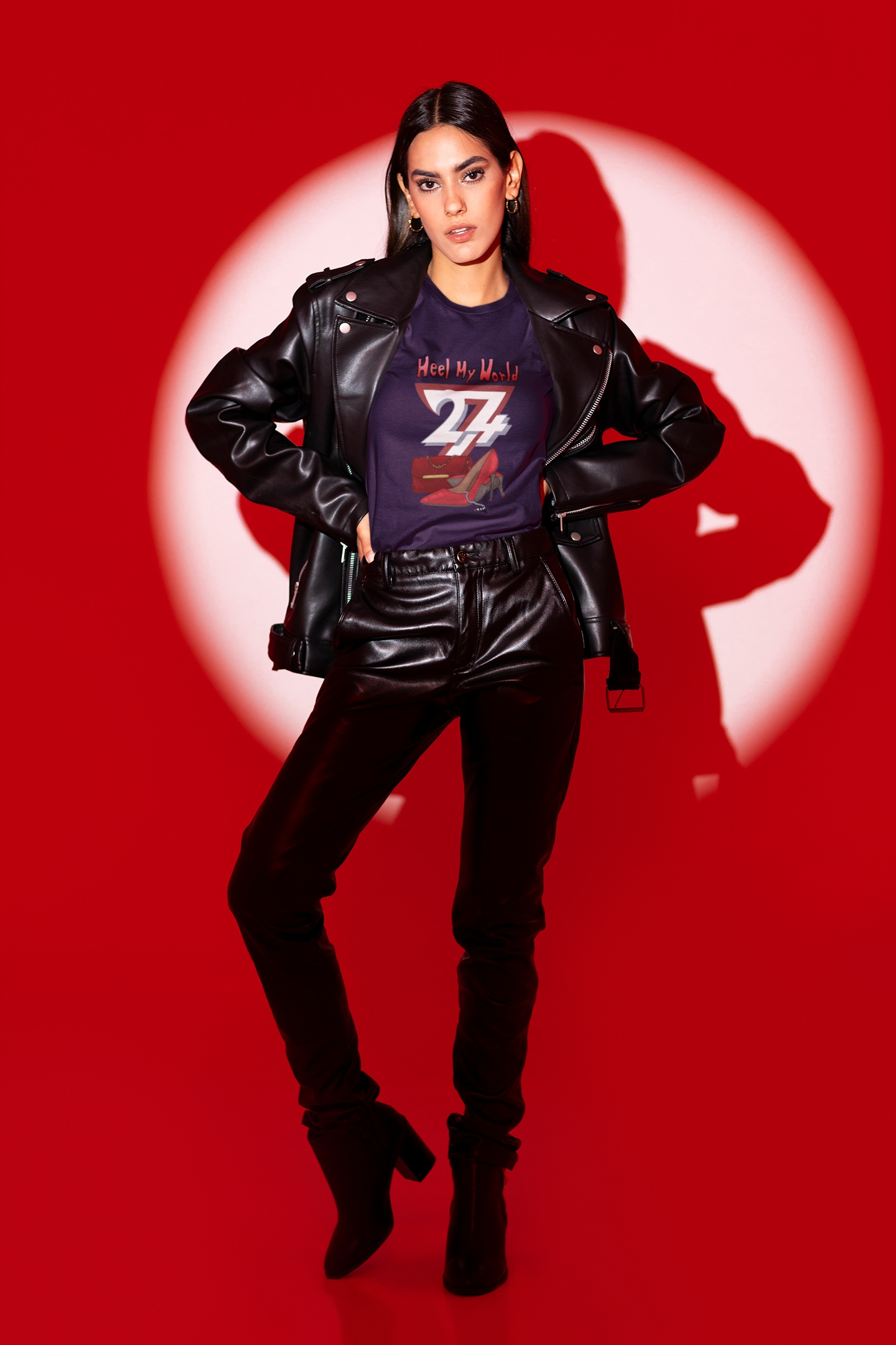 Female model styling the purple fashion lover women's top with black leather pants and a leather jacket, posing dramatically in front of a red studio spotlight.