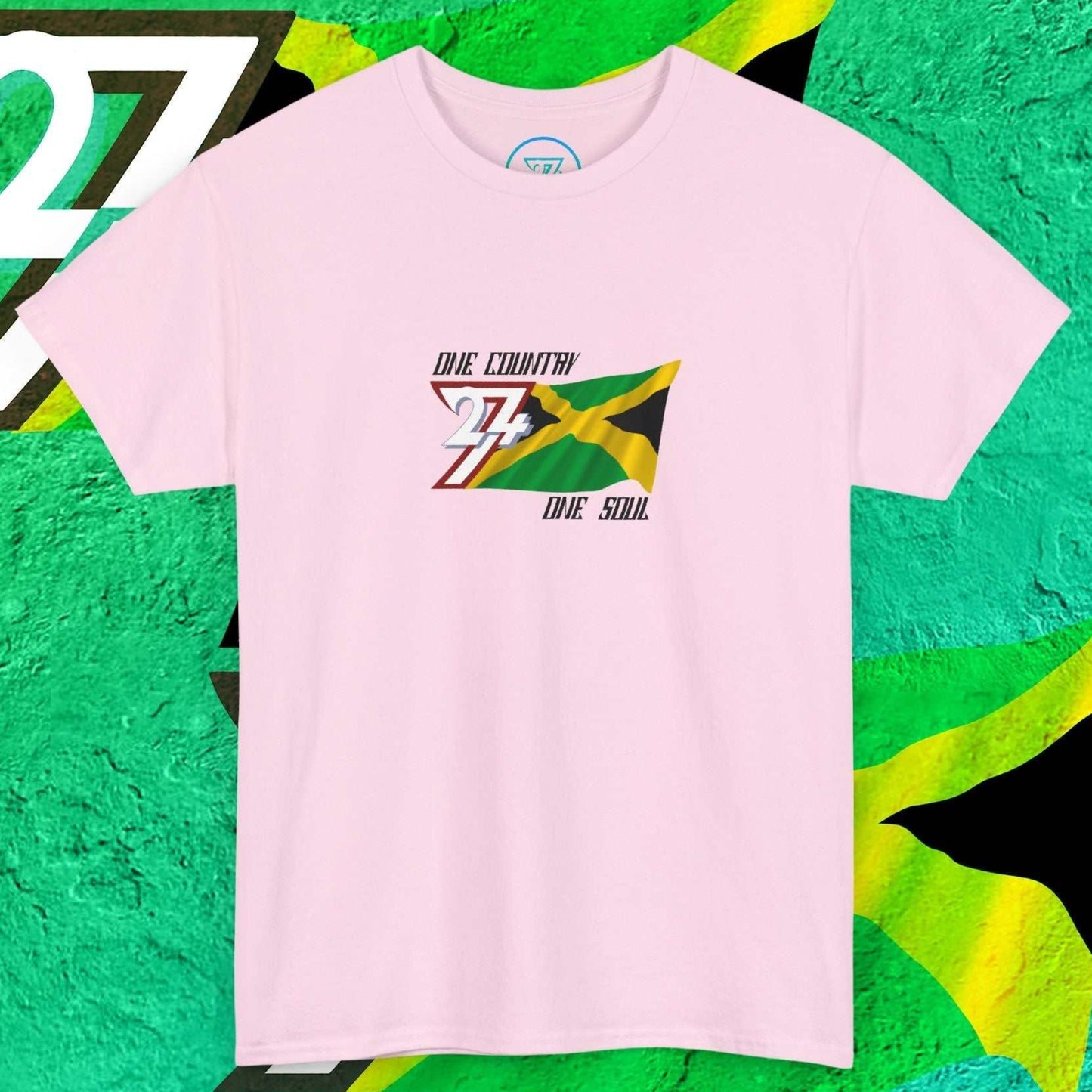 Front view of a light pink Jamaica flag tee highlighting the sketched artistic textures and "One Country One Soul" slogan.