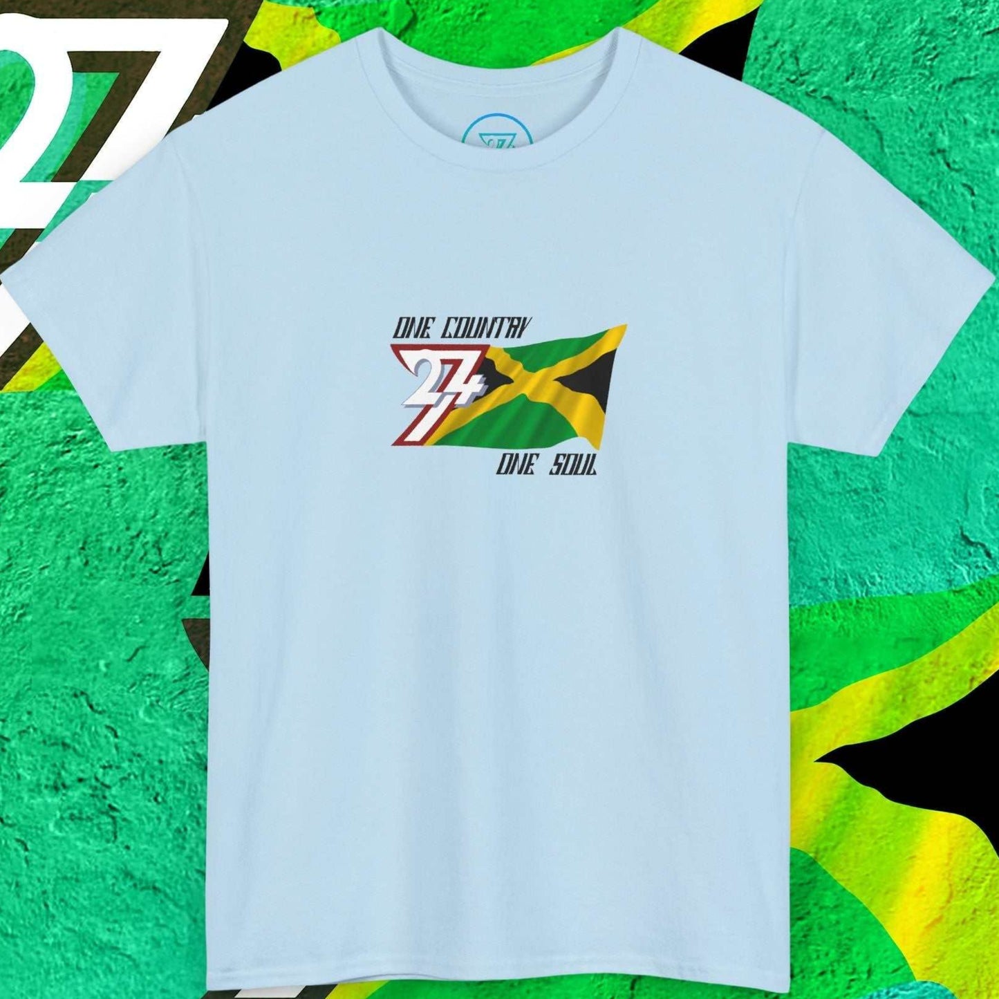 Hand-drawn Jamaican cross design on a light blue t-shirt featuring the "One Country One Soul" branding.