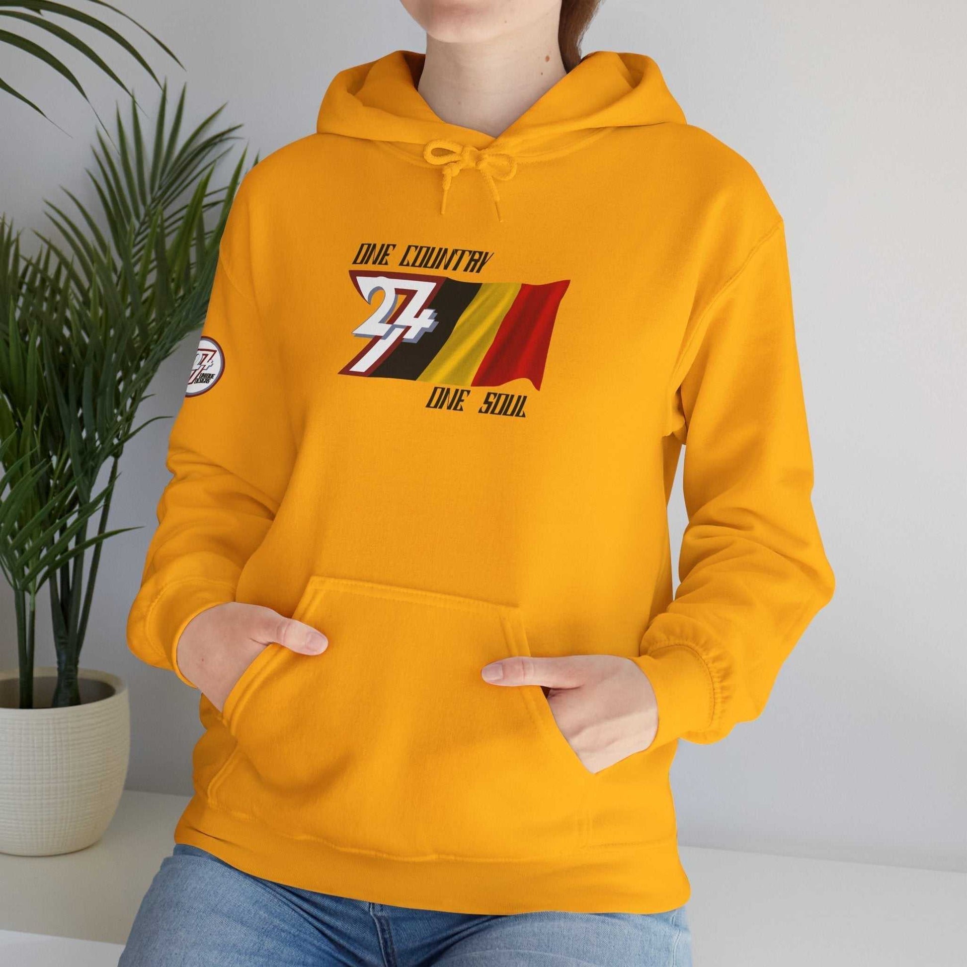 Model wearing the België "Colloquy" hoodie in Gold, styled for a modern streetwear look.