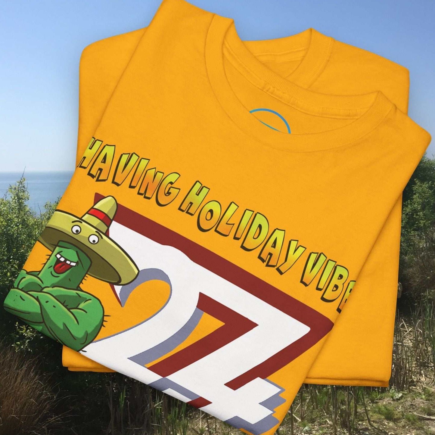Folded golden yellow t-shirt neatly displaying a printed flexing cartoon cactus graphic.