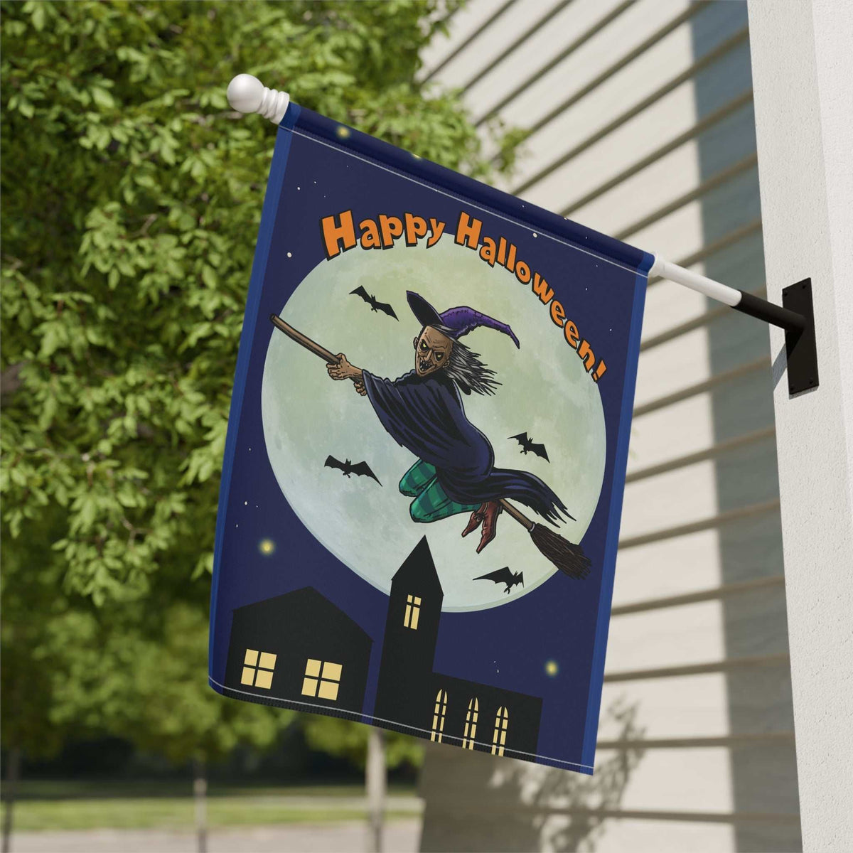 Close-up outdoor view of the double-sided yard flag displaying the digitally hand-drawn flying witch graphic, mounted securely on a residential siding wall in the daylight.