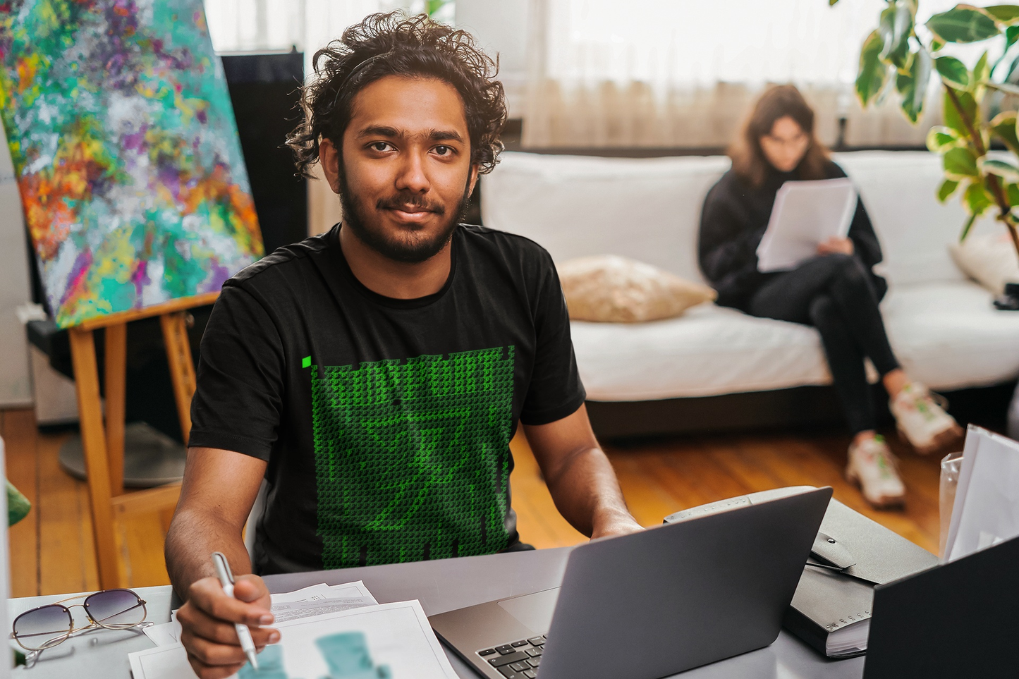 Front facing man styling the Matrix inspired tech shirt at a desk with laptop