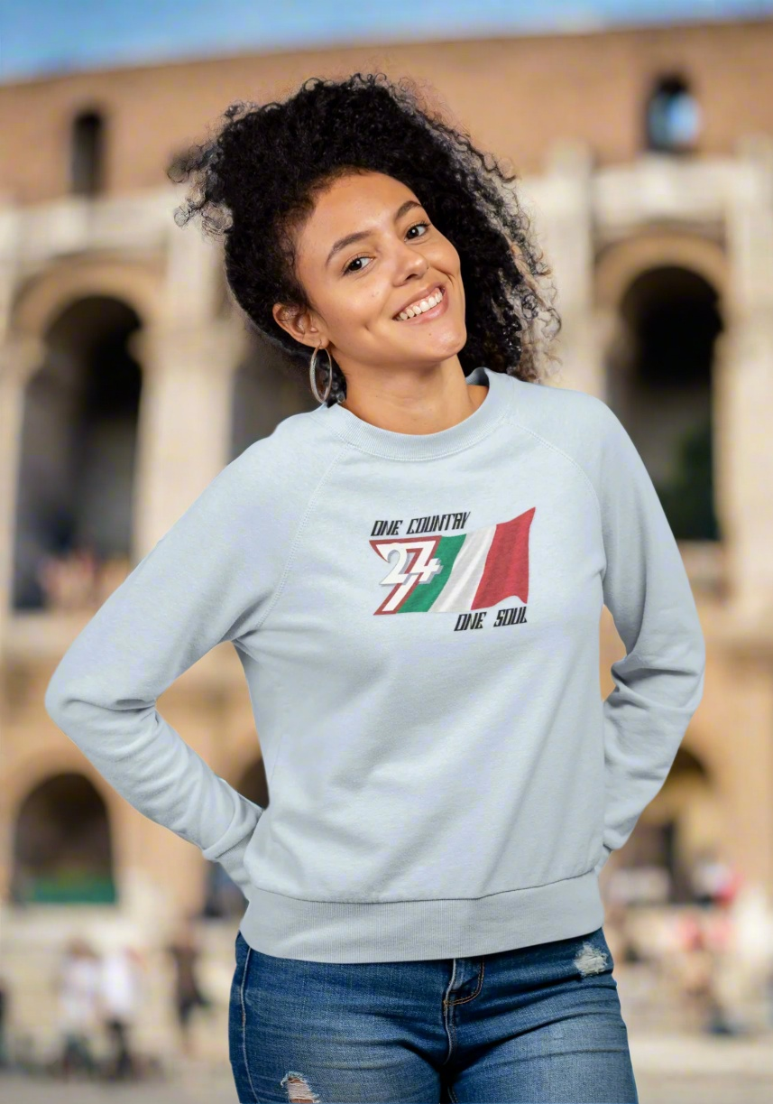 Woman wearing light gray Italy flag sweatshirt with hand-drawn design outdoors by historical building