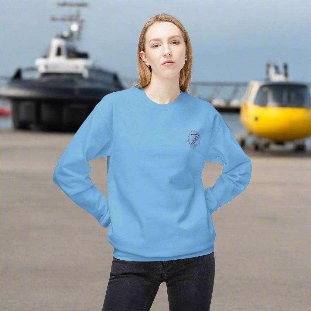 Woman wearing a light blue everyday sweater featuring a small hand-drawn front flower logo.