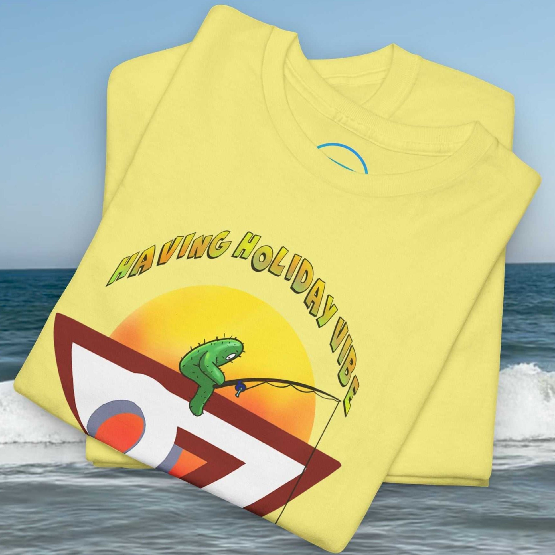 Folded light yellow t-shirt neatly displaying a printed cartoon cactus and sunset graphic.