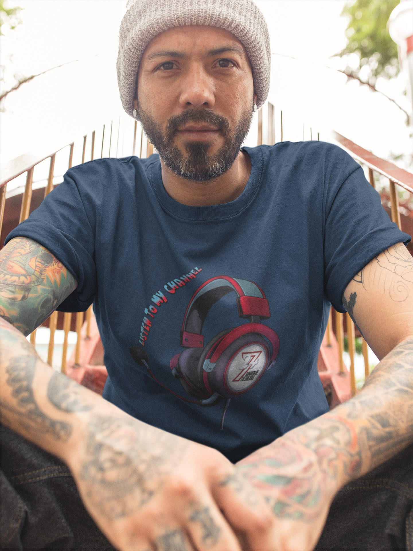 Male model wearing the dark navy content creator graphic tee showcasing the vibrant tech art, sitting outdoors on metal stairs.