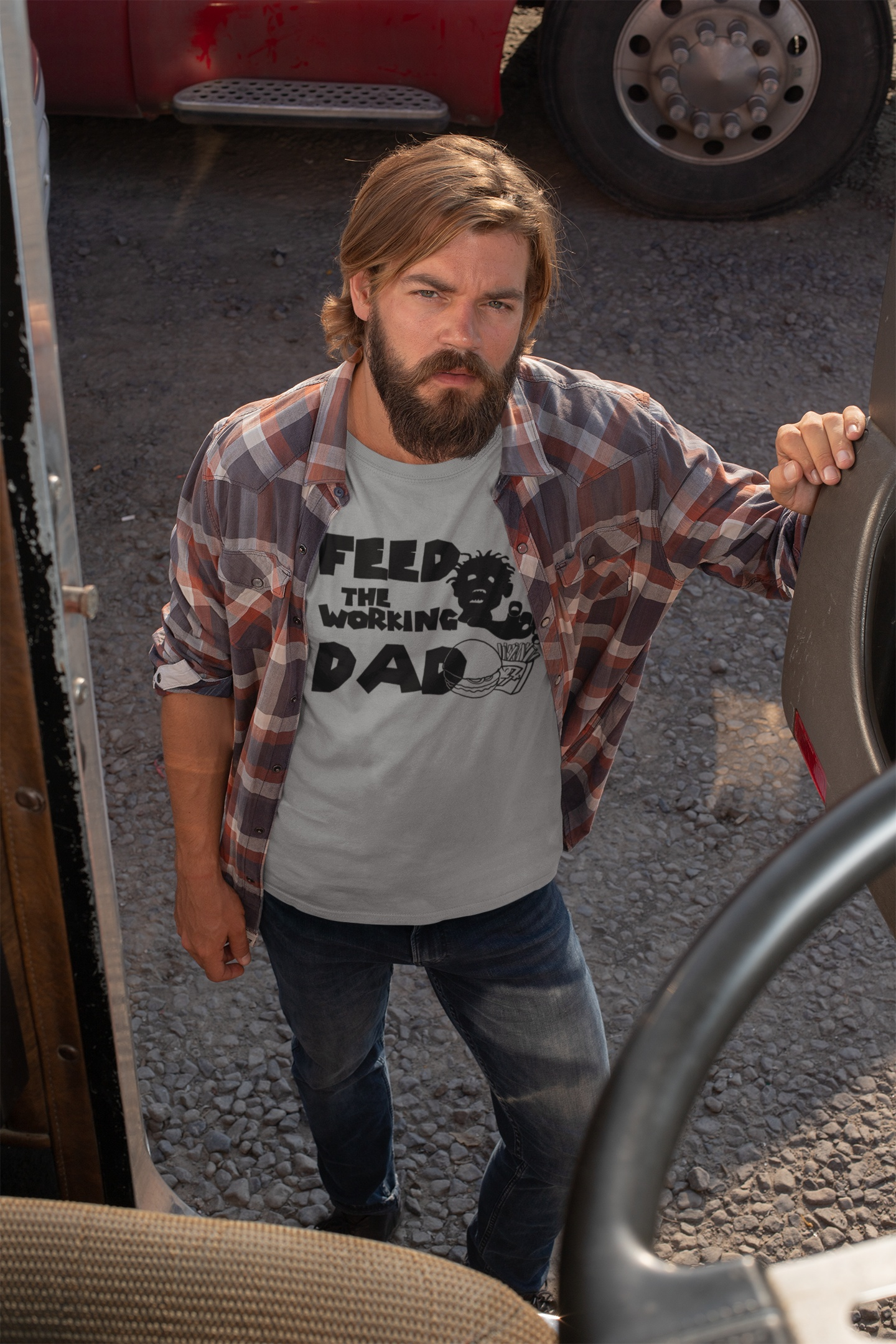 Male model styling the sport gray horror parody Father's Day shirt in a transport working environment.