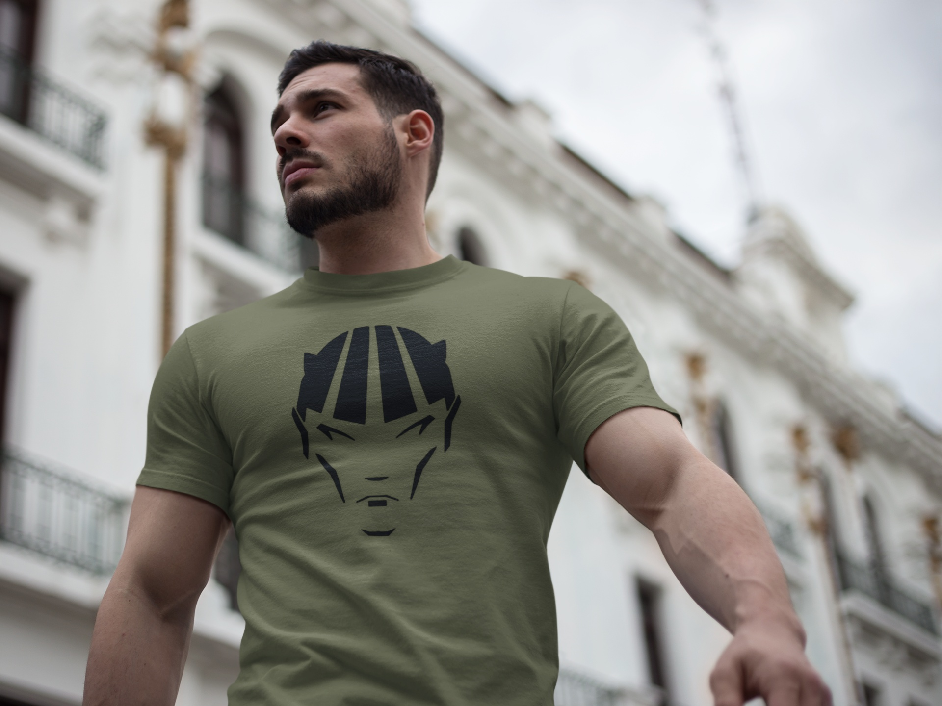 Man styling the army green dark fantasy comic character tee in a casual outdoor urban environment.
