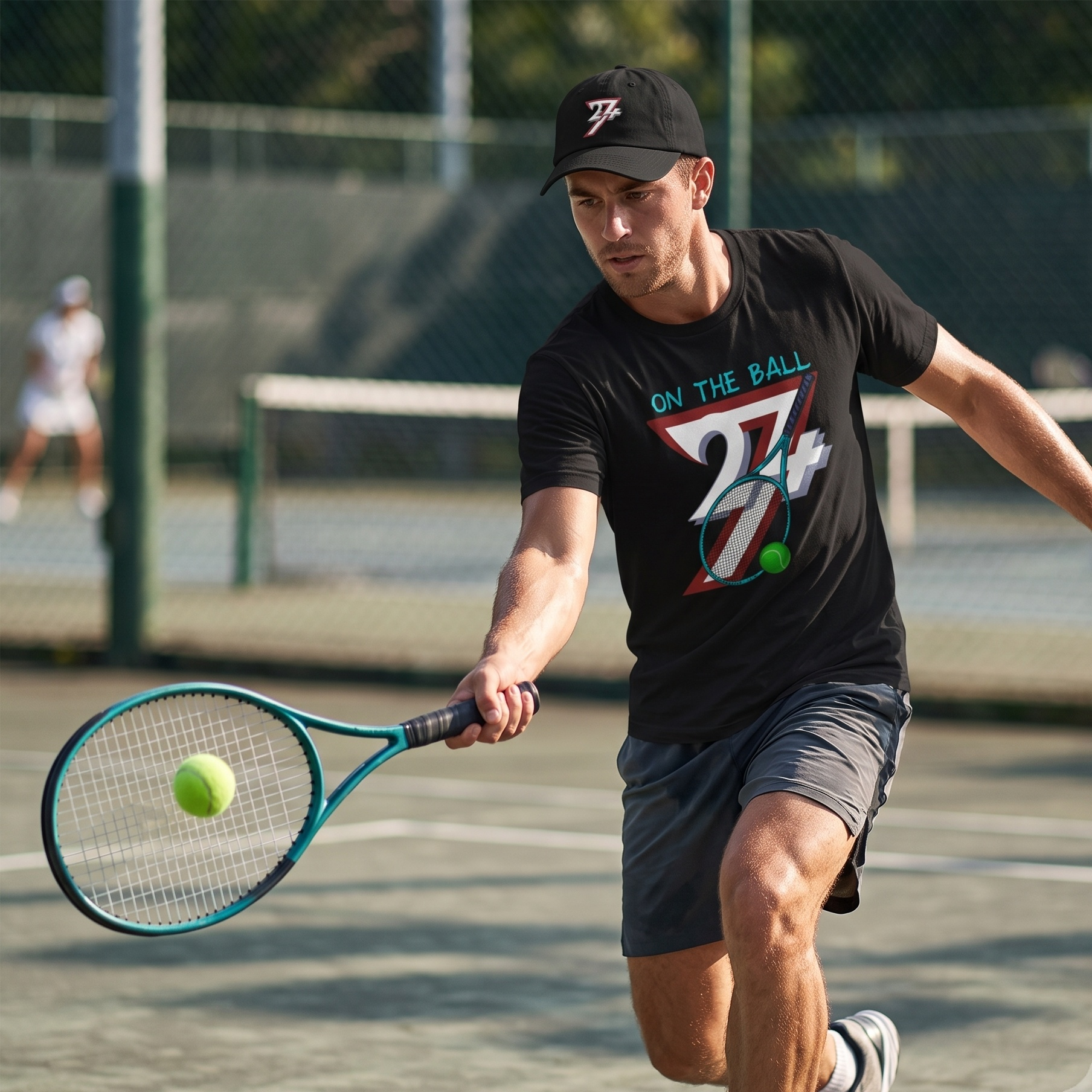 Focused male tennis player hitting a forehand on an outdoor hard court, wearing a black 24/7 cap and the black retro racket and ball shirt to showcase the athletic streetwear aesthetic.
