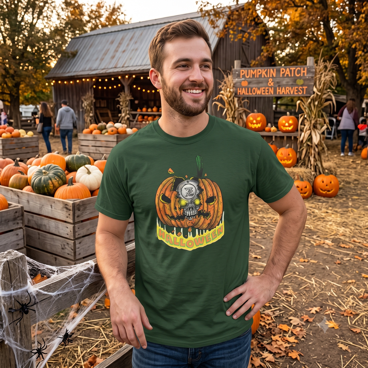 Cheerful man standing at a rustic outdoor pumpkin patch and Halloween harvest display, wearing the forest green spooky graphic shirt.