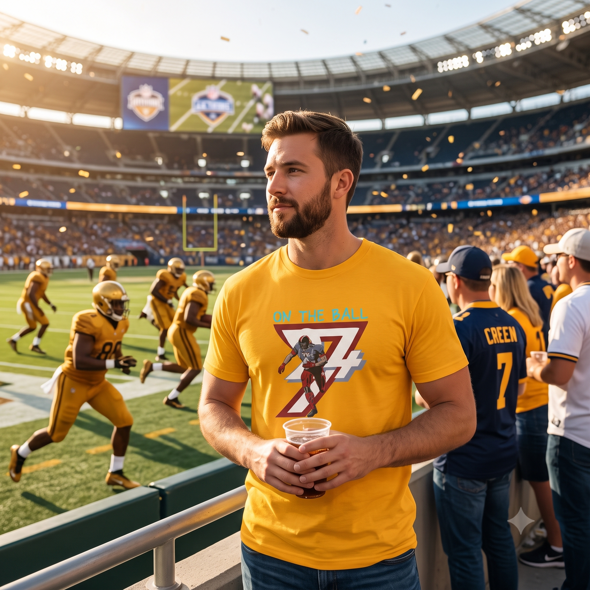 Confident male football fan standing in the stadium stands holding a drink, wearing the vibrant gold tailgate apparel tee while watching the game under stadium lights.