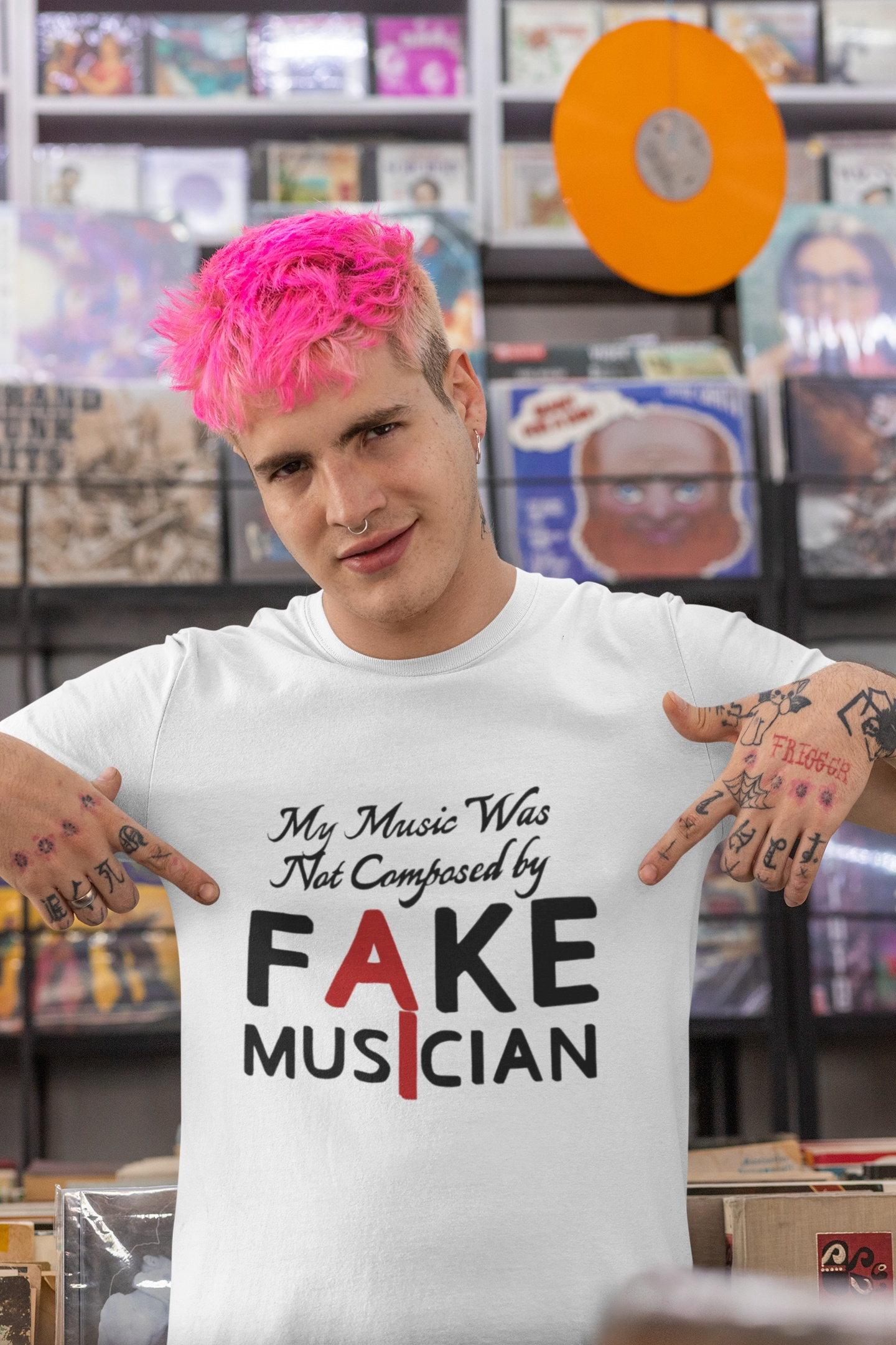 Male model with pink hair styling the white support human musicians graphic tee, pointing proudly at the clever typography print while standing inside a colorful record store.