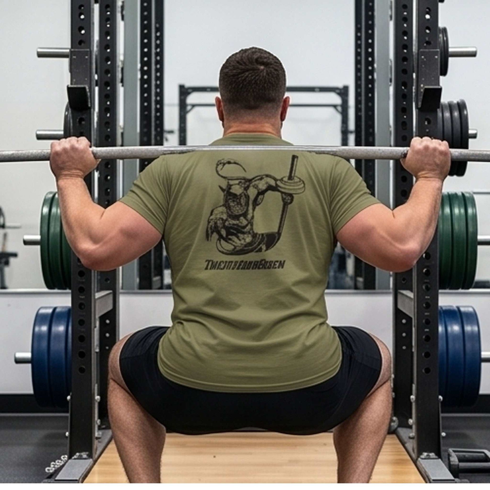 Male model seen from the back wearing the military green retro comic workout gear tee, performing a heavy barbell squat in a power rack, perfectly showcasing the underground comic back graphic.