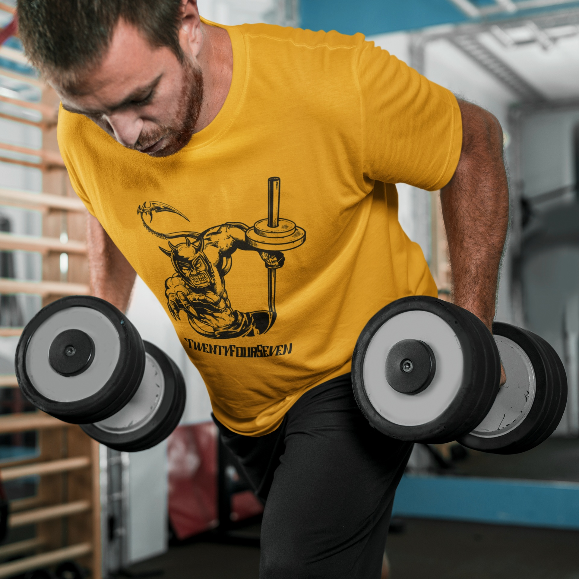 Bearded male model wearing a dark comic style gym tee, mid-workout during a heavy strength training session, highlighting the shirt's athletic fit and durable fabric.