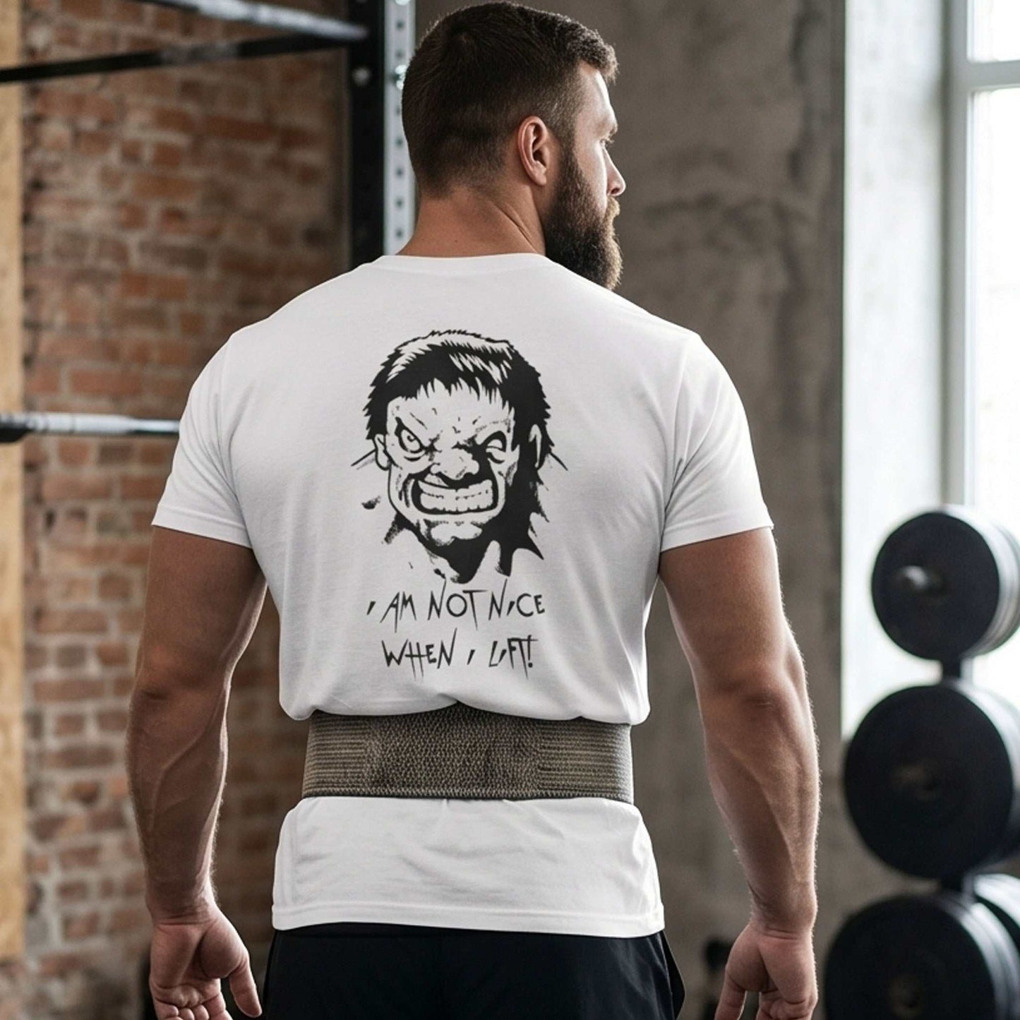 Muscular male model wearing a lifting belt and the white sarcastic gym shirt, standing confidently in a gym setting to emphasize the funny back graphic.