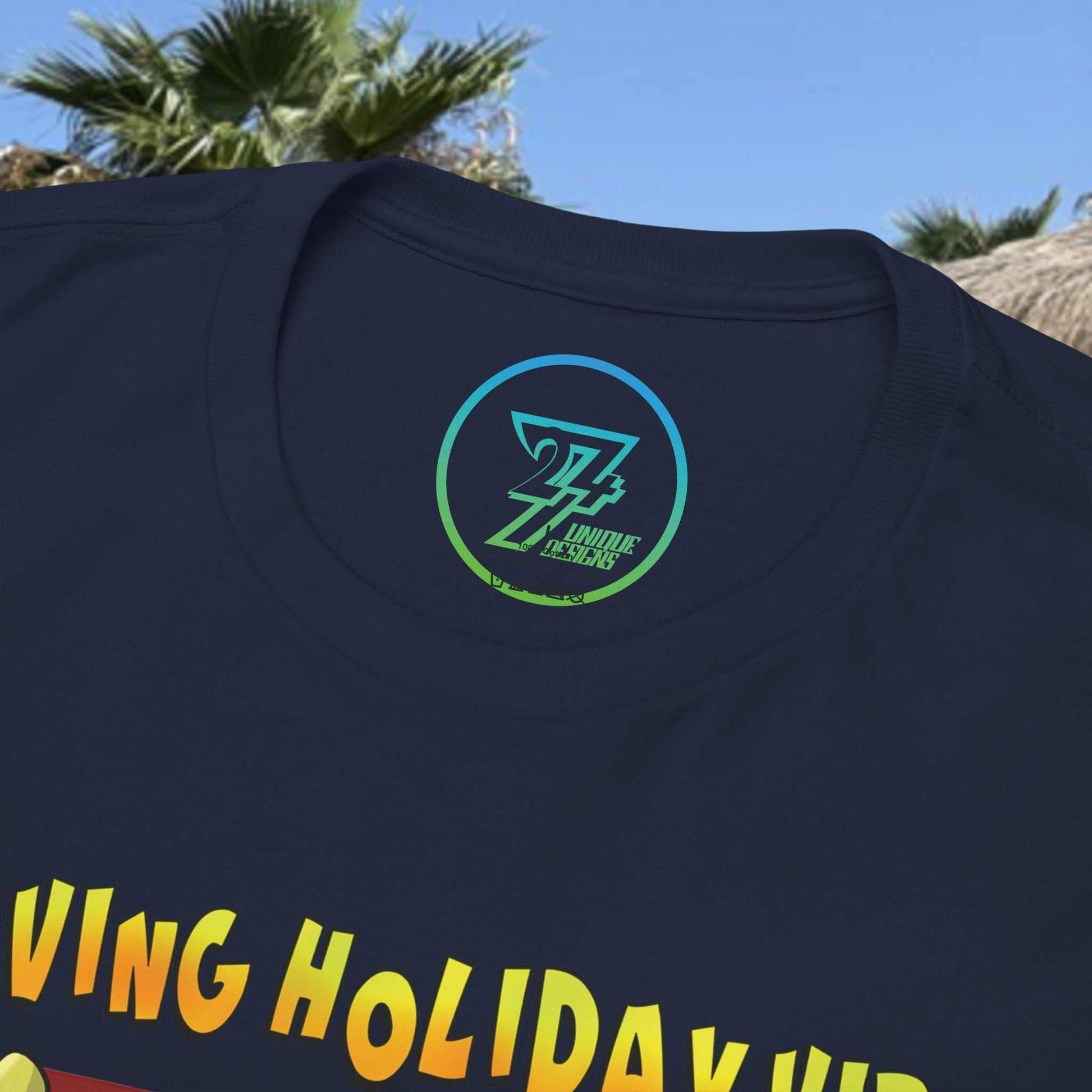 Close-up of a navy blue t-shirt collar showing a neat crew neckline and the printed 24/7 Unique Designs trademark neck label.