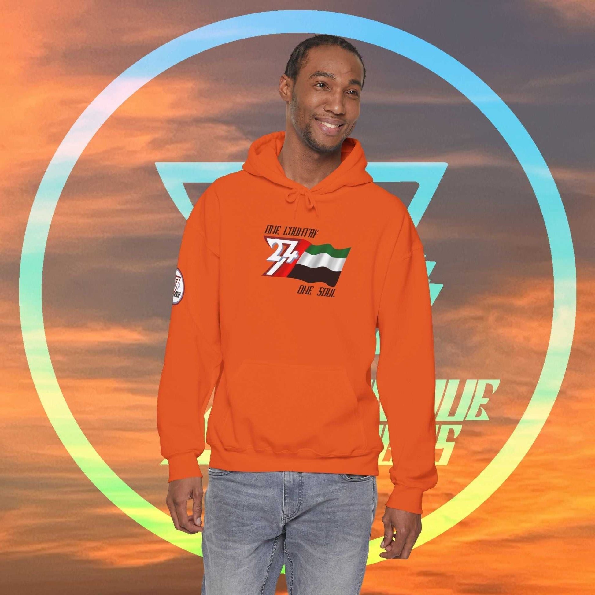 Male model wearing the UAE "Vision" edition hoodie in Orange, showing a modern, refined streetwear look.