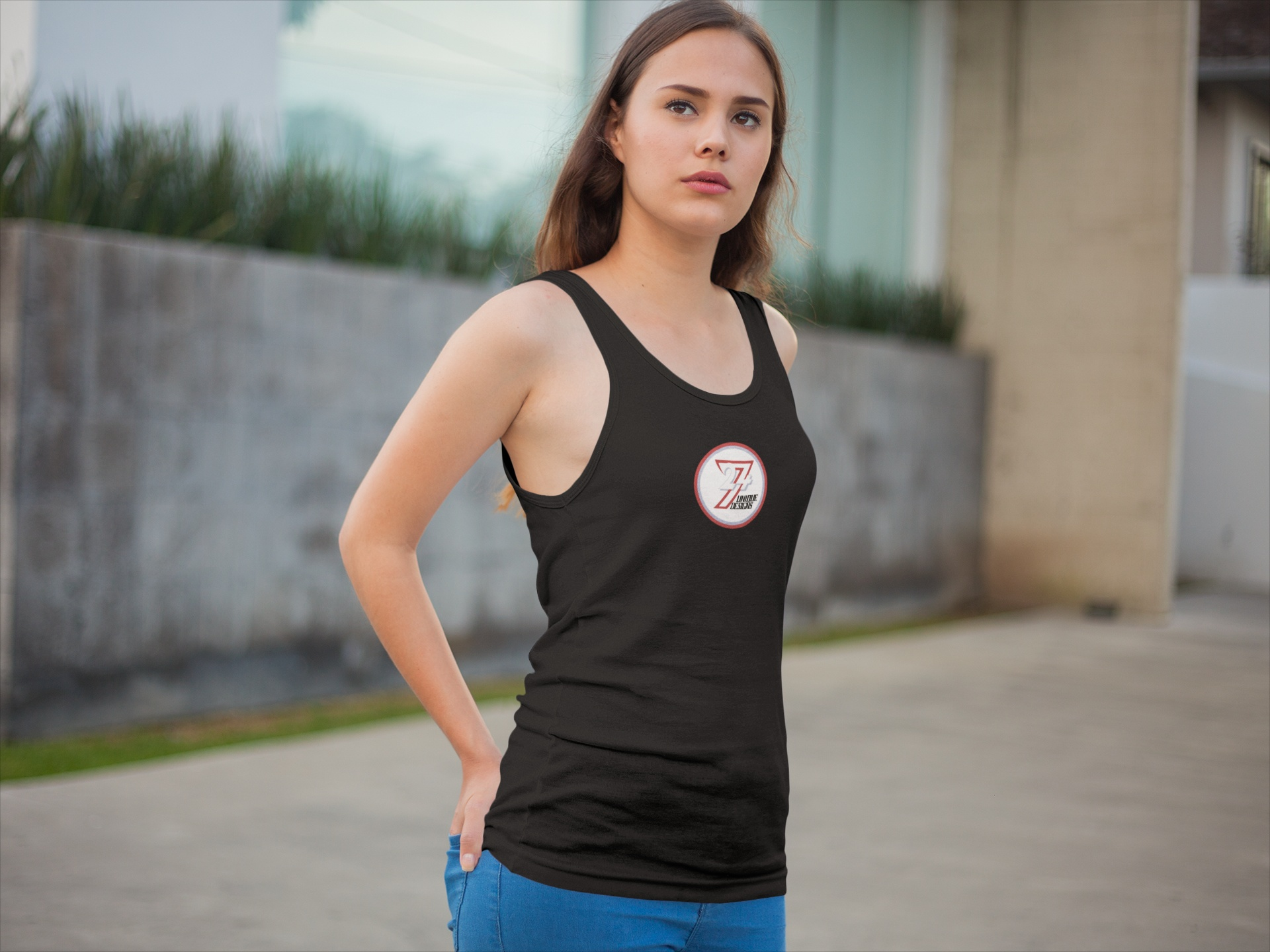 Woman modeling a sleek black 24/7 core brand tank shirt in a stylish urban street context.
