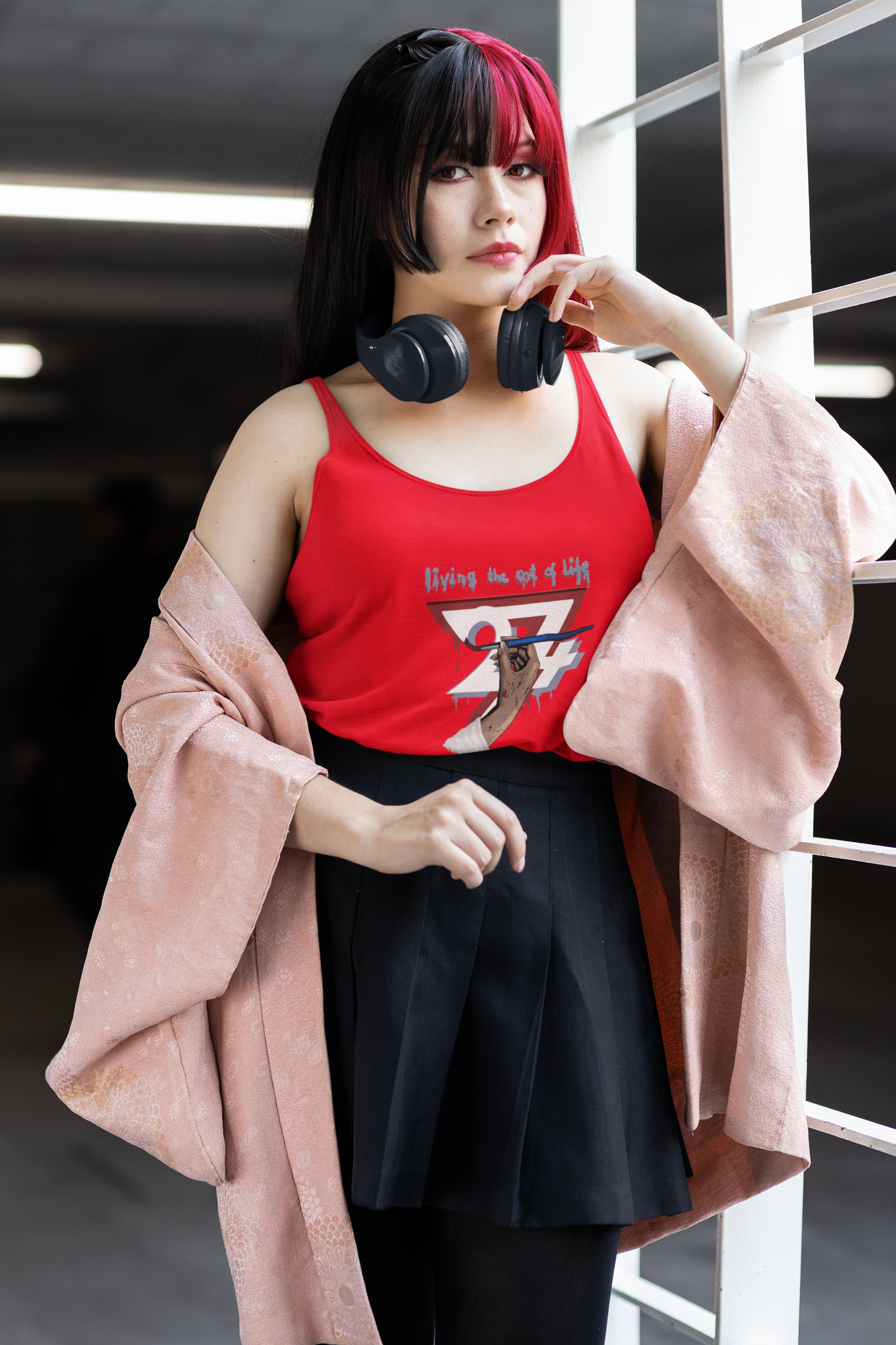 Female model wearing the red women's jersey tank top featuring an illustration of a hand holding a paintbrush with the text Living the Art of Life.