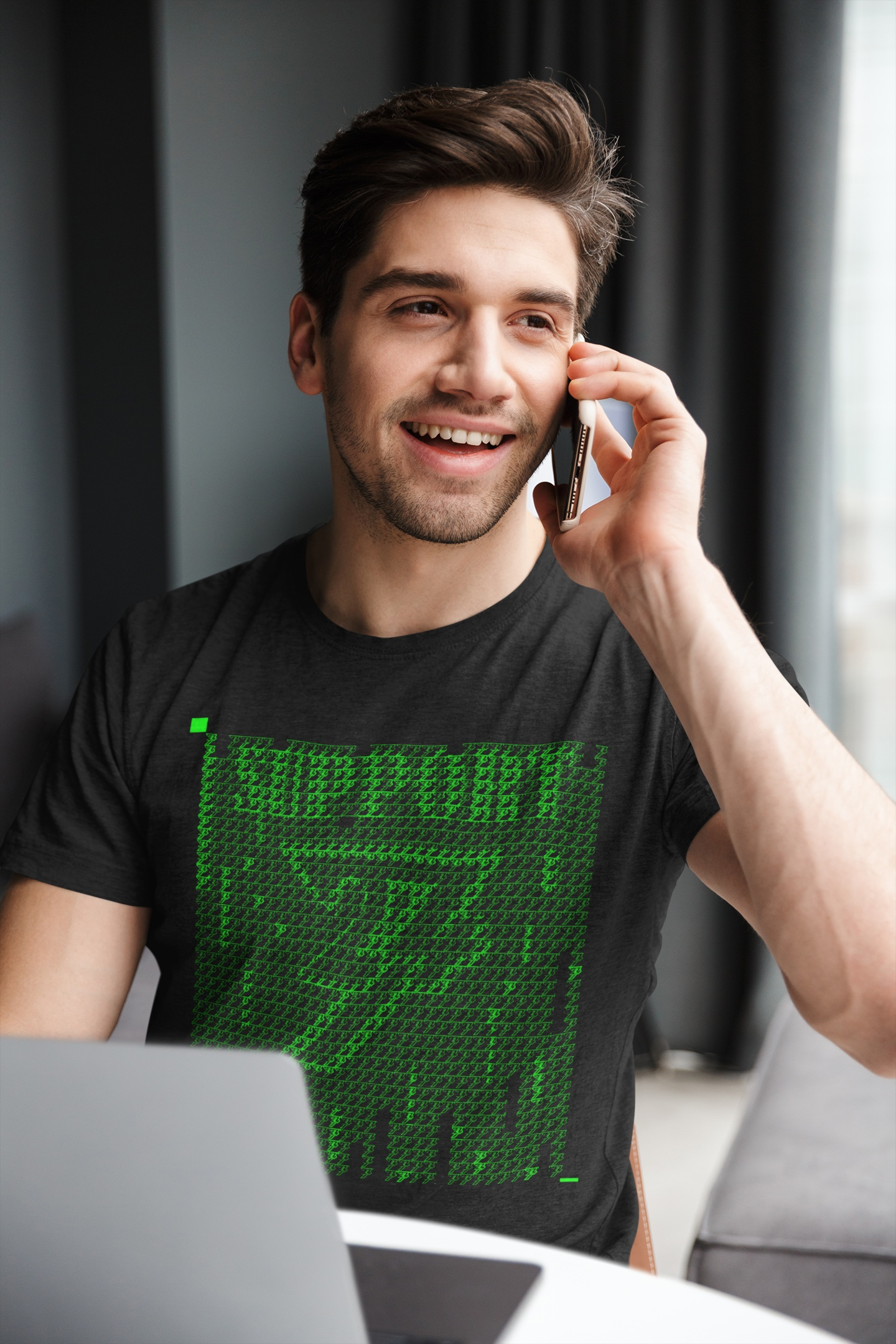 Black IT support graphic tee featuring a green digital rain design, worn by a man sitting at an office desk.