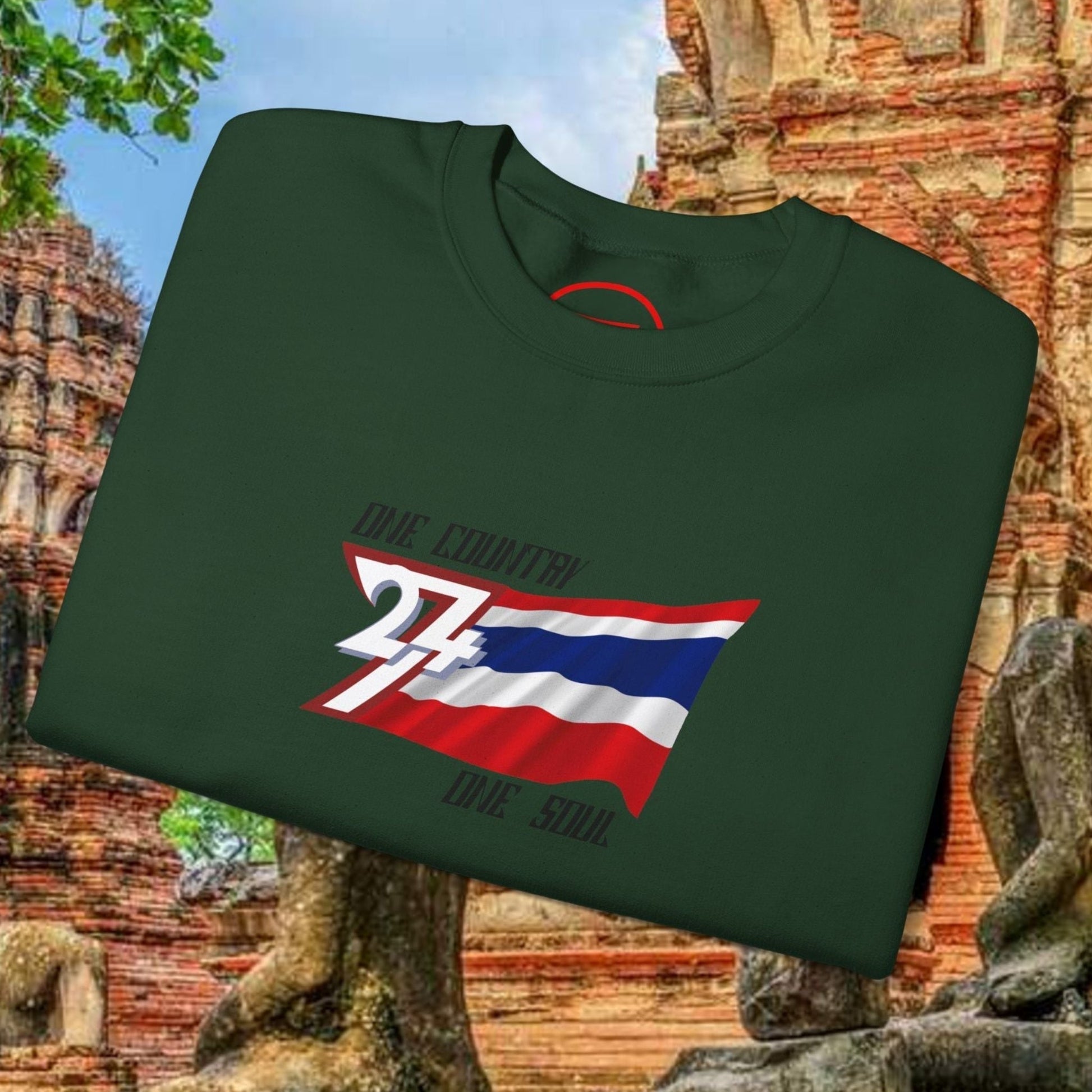 Green crewneck sweatshirt featuring a hand-drawn Thailand flag with "True Thailand True Soul" text, made of cotton-poly blend, displayed in front of ancient temple ruins.