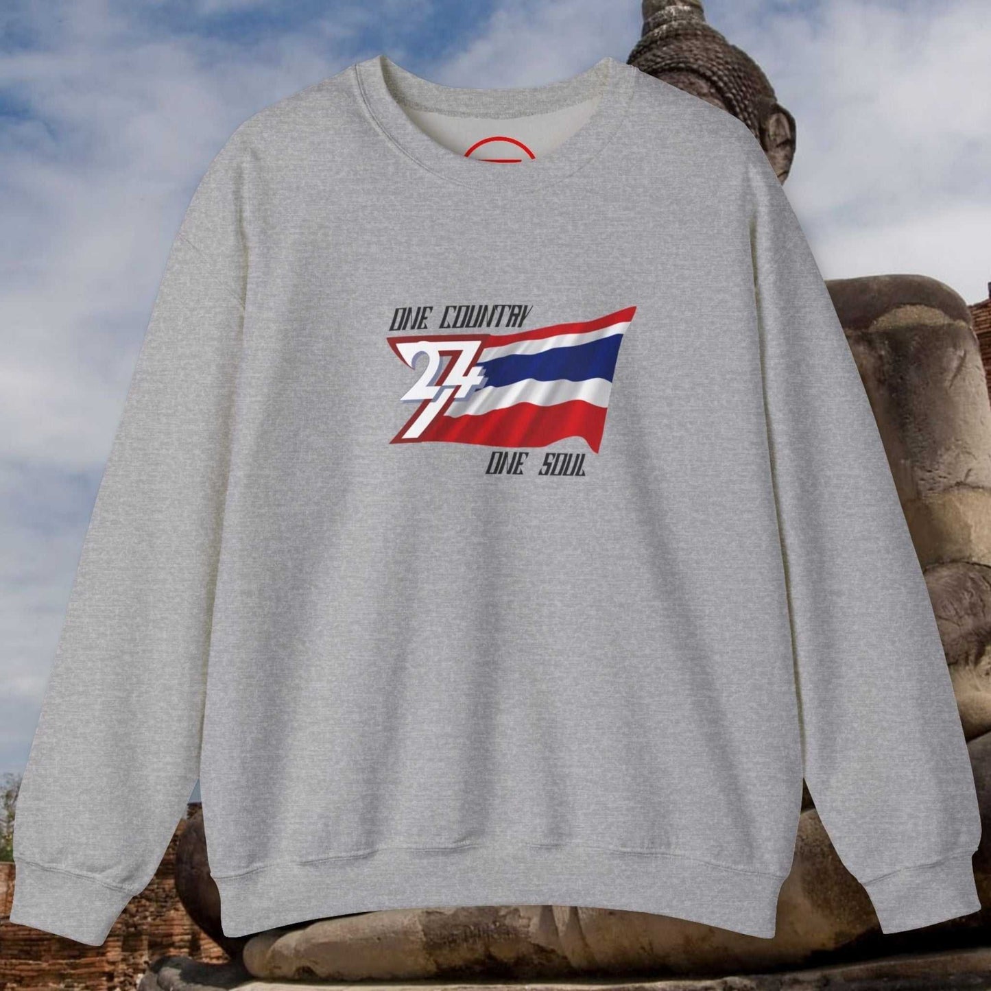 Gray crewneck sweatshirt featuring hand-drawn Thailand flag with "One Country One Soul" text, midweight cotton-poly blend, displayed outdoors.