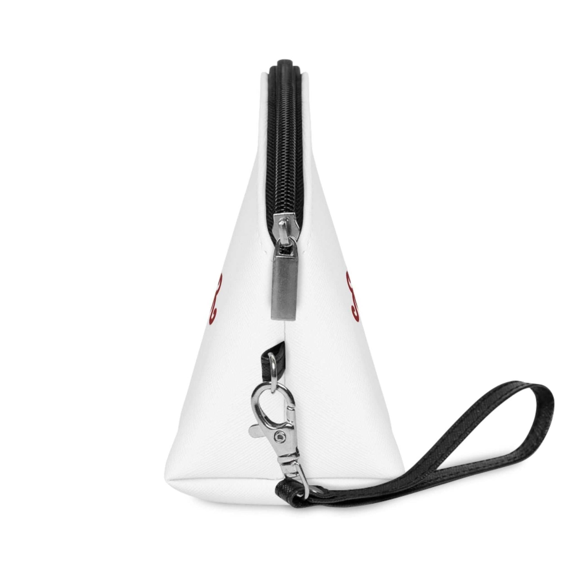 Left side profile of the travel beauty case, highlighting the structured triangular gusset, the silver zipper hardware, and the detachable black wristlet strap.