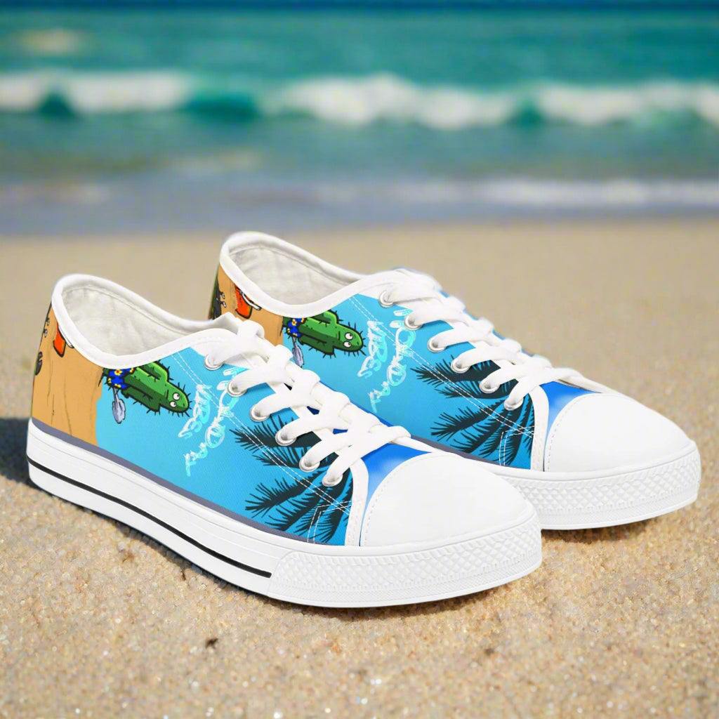 Women's low top Tropical Canvas Sneaker with tropical beach design and white rounded pleather toe on sand background