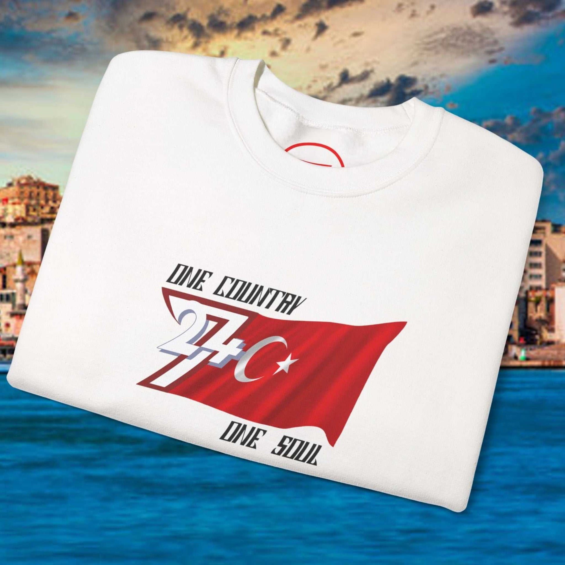 White Turkish Flag sweatshirt with hand-drawn red flag design and "One Country One Soul" text on a coastal city background