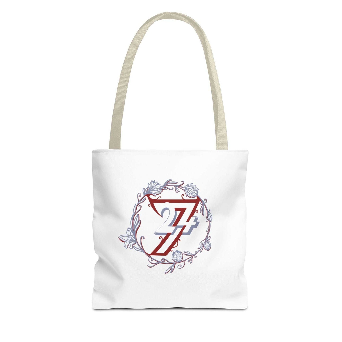 A white canvas tote bag with beige shoulder straps, featuring a central graphic of a red stylized 24/7 logo inside a circular frame with blue and gray floral details.