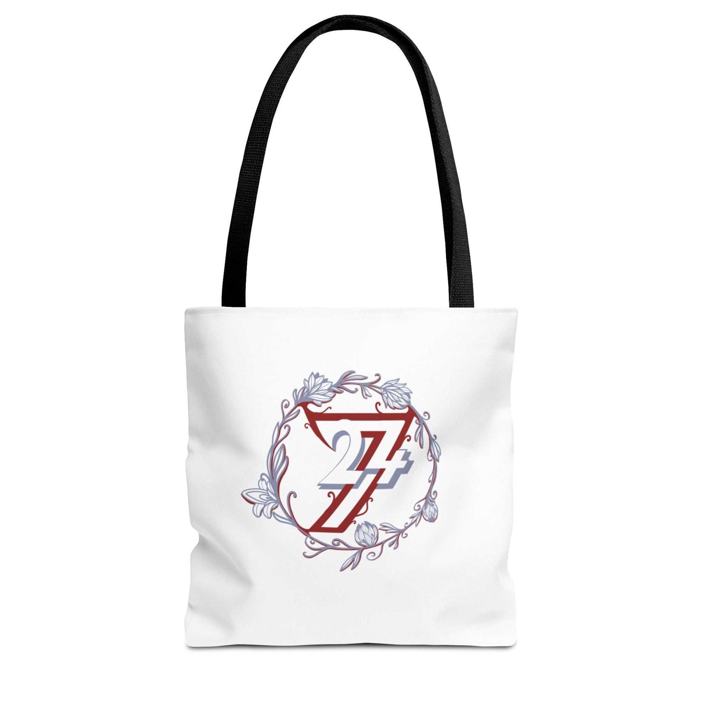 A white canvas floral tote bag with black shoulder straps, featuring a central graphic of a red stylized 24/7 inside a circular floral wreath with blue and gray accents.