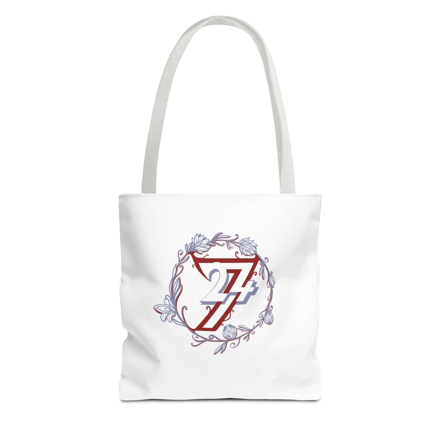 A white canvas floral tote bag with two white shoulder straps, featuring a central graphic of a red stylized 24/7 logo inside a circular frame with a lavender floral wreath.