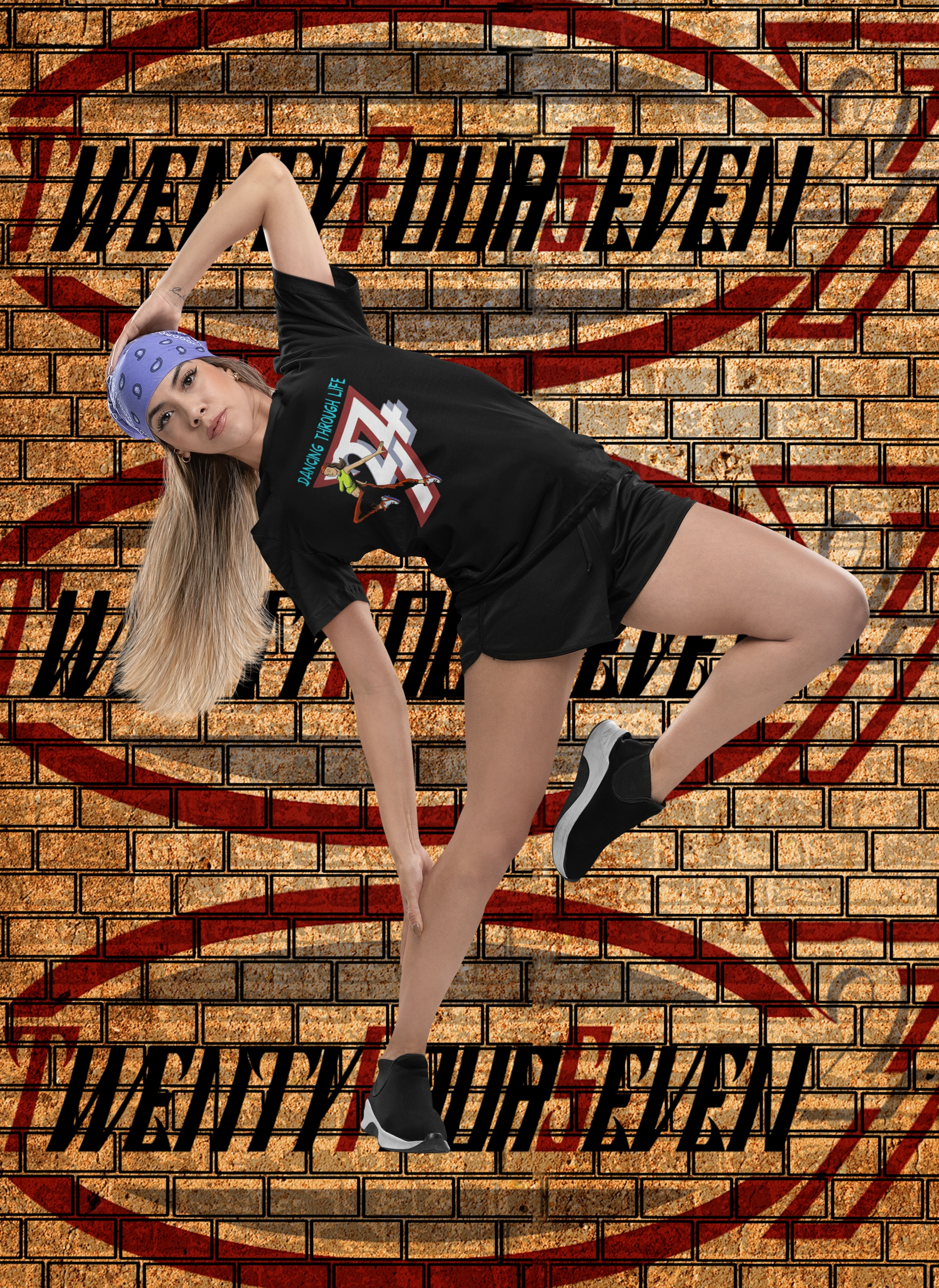 Athletic woman in a dynamic hip-hop dance pose inside a studio with a stylized brick wall backdrop, wearing the black Dancing Through Life street dance graphic tee and a purple bandana.