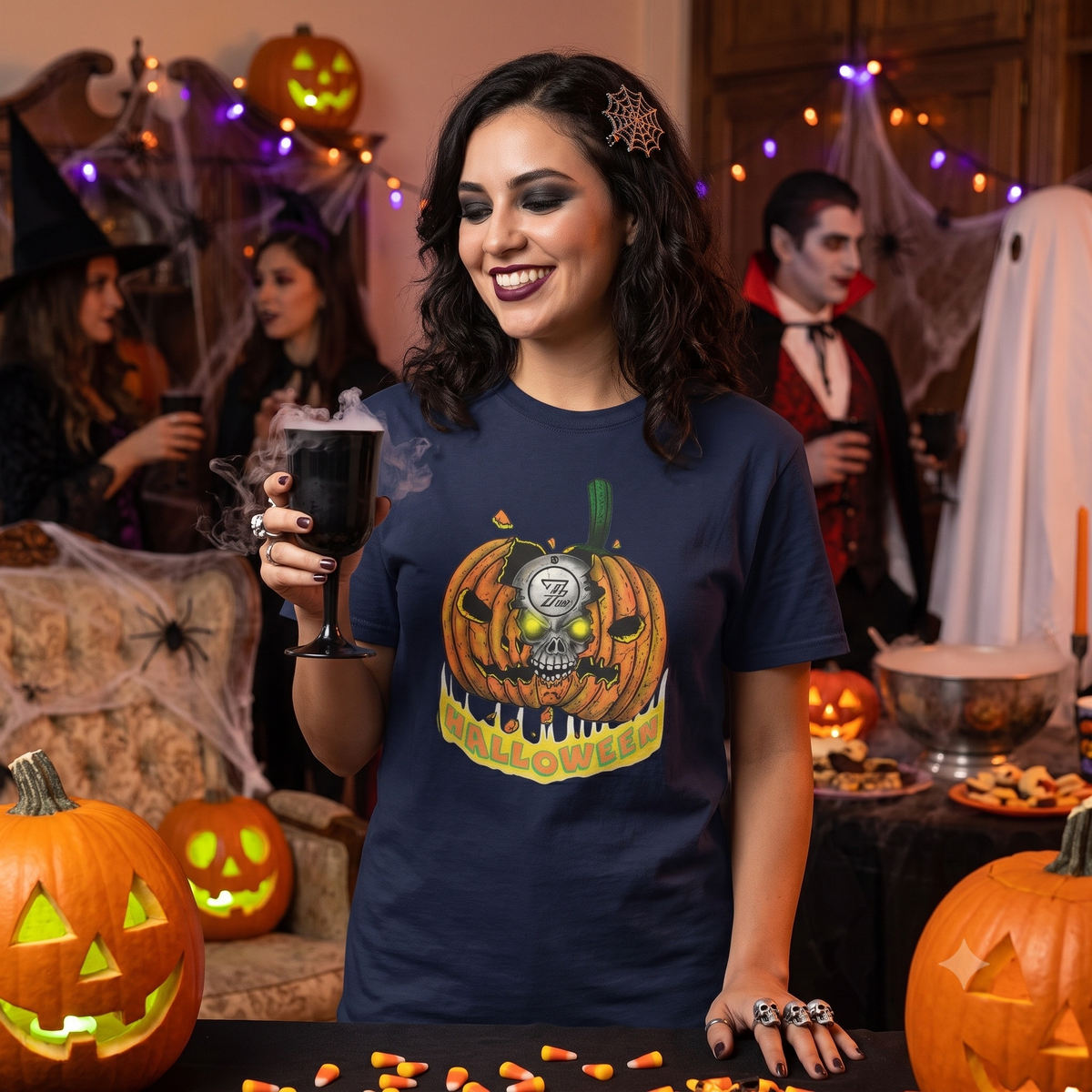 Happy young woman enjoying an indoor Halloween party, holding a smoking black goblet while wearing the navy blue hand-drawn jack-o-lantern t-shirt.